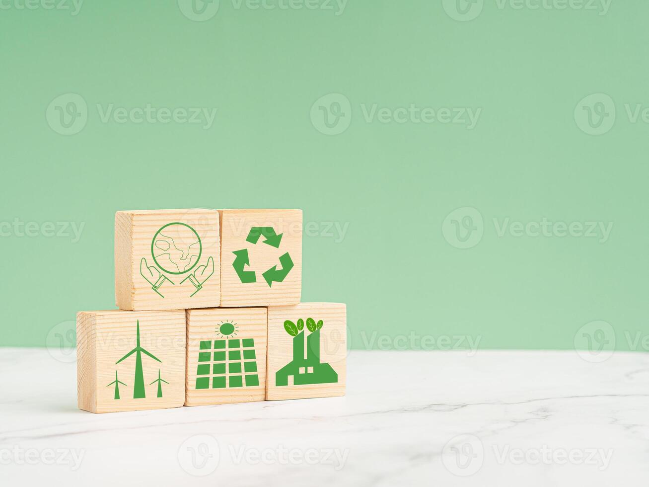 Net-zero greenhouse gas emissions target. Wooden cubes with green icons over a marble floor against a light green background photo