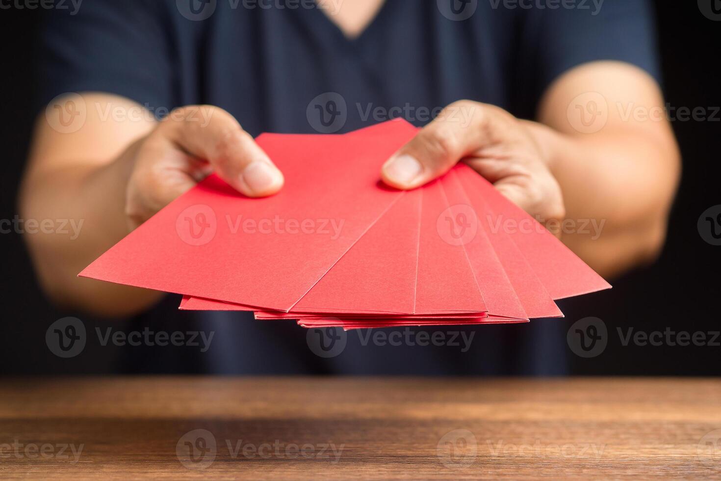 Man in casual holding a red envelope. Close-up photo