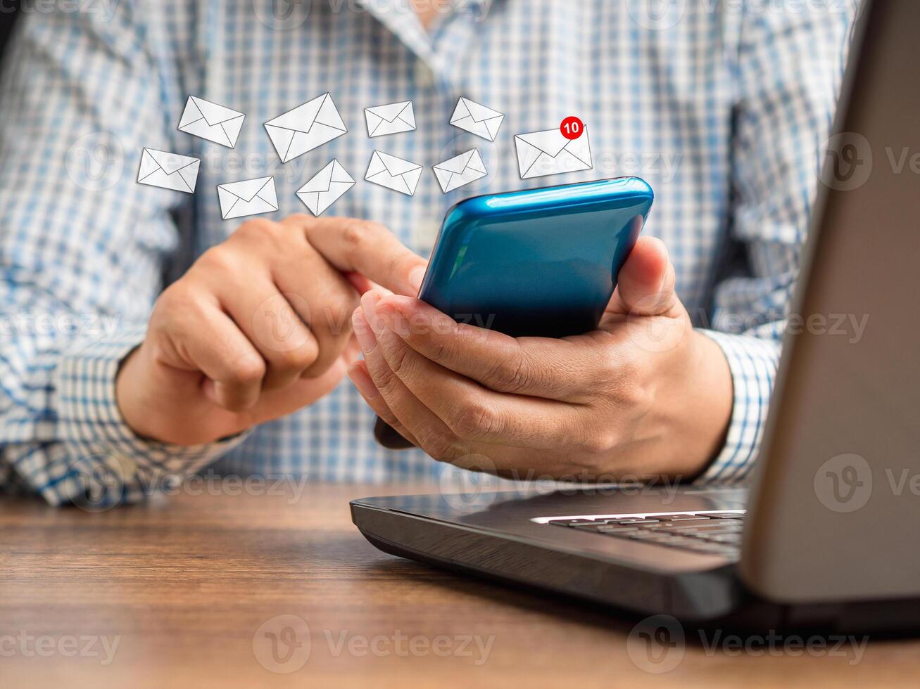 Businessman holding a smartphone receives a new message with email icons photo