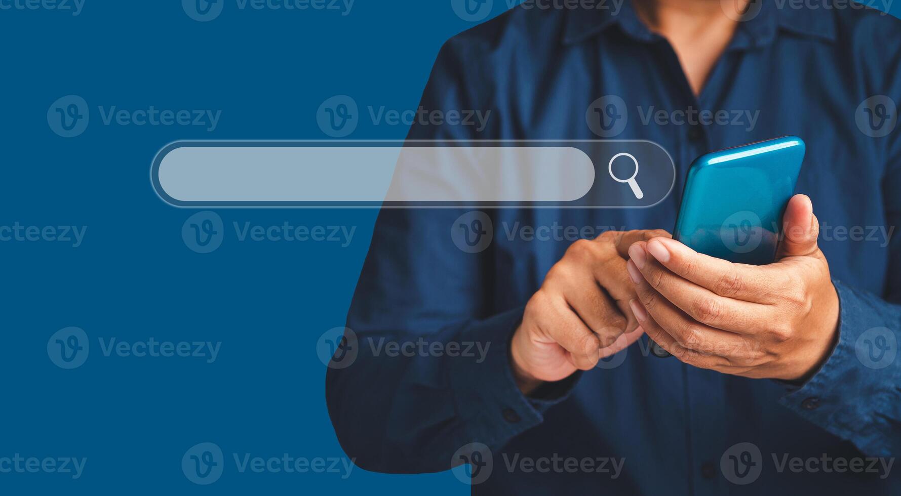 Close-up of hand a man using a mobile phone search for information interest on search engine website while standing on a blue background photo