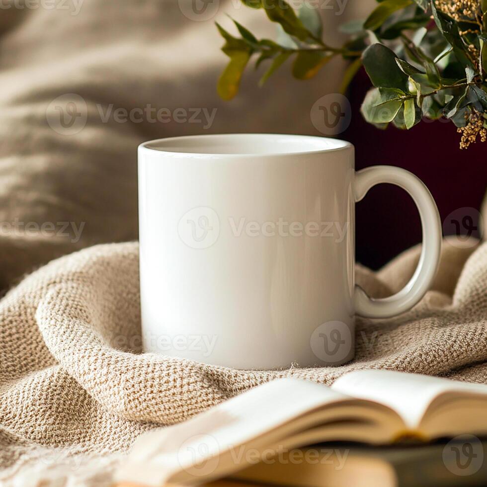 A white mug and book on a blanket photo