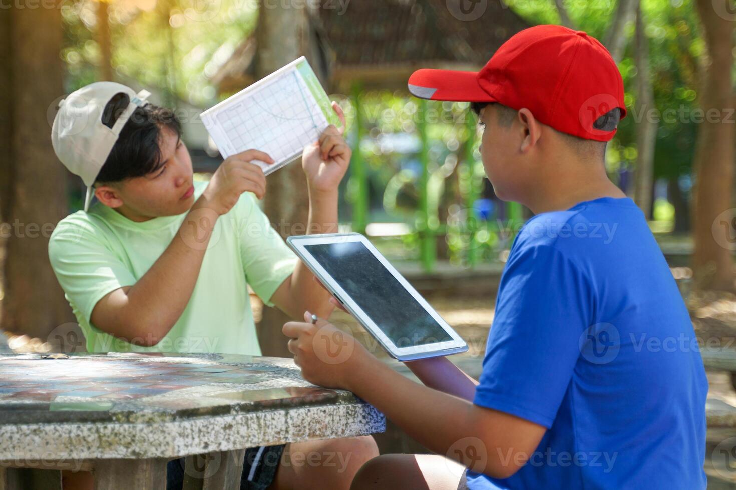 The boys used a clinometer to measure angles and take notes to calculate the height of the trees and calculate the trees' carbon storage. photo