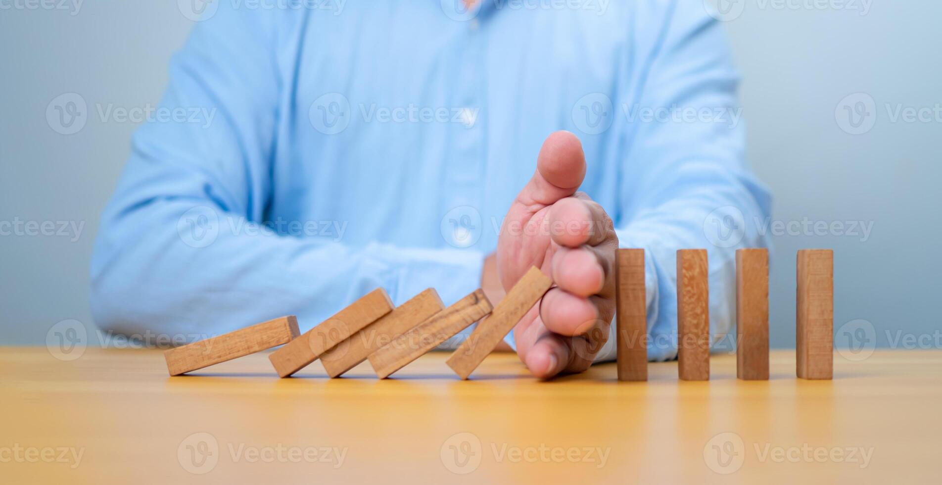 Businessman hand Stopping Falling wooden Blocks or Dominoes, Business, Risk Management, Solution, Insurance and strategy Concepts, Risk and strategy in business. photo