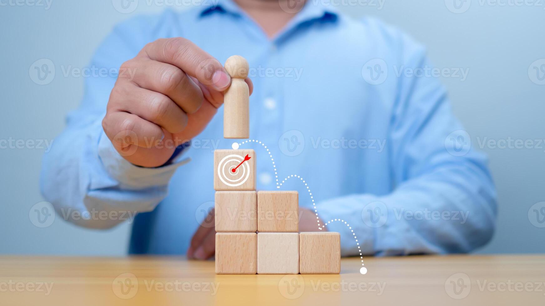 Hand man place wooden top of state or the winner, Concept of success, Winning and accomplishment in business. A man holding wooden doll model standing on target icon, Leadership and superiority. photo