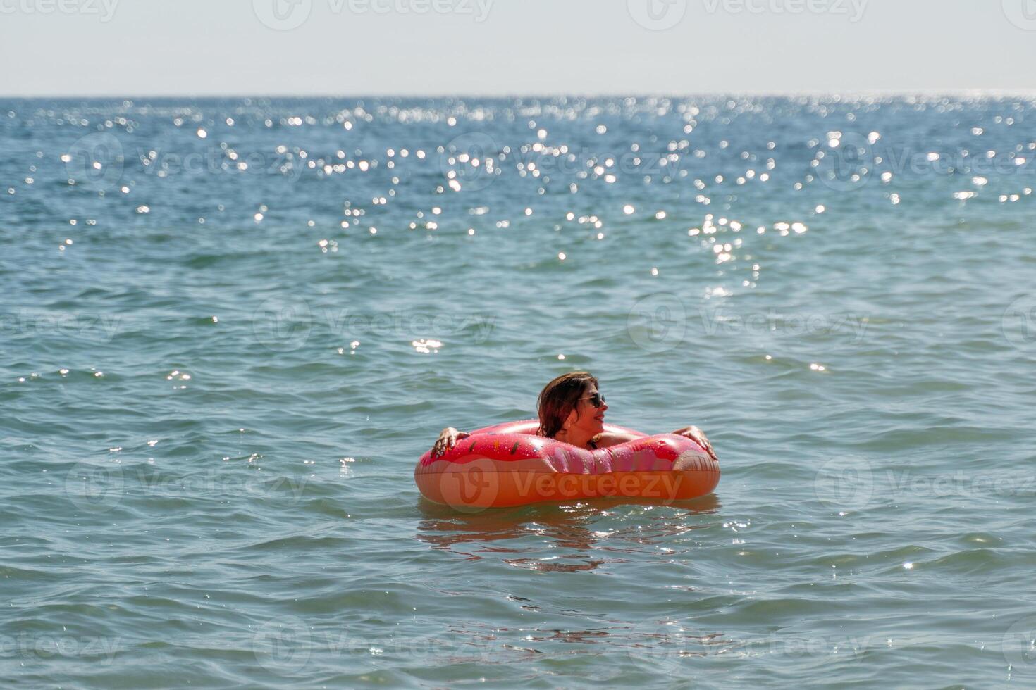 Child Inflatable Ring Ocean - A child floats on an inflatable ring in the ocean on a sunny day. photo