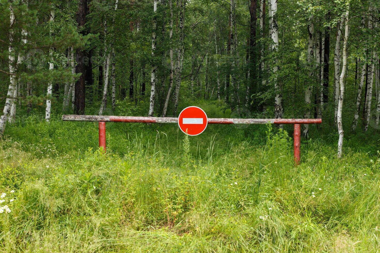 Closed barrier and prohibition sign near the forest. Entry into the forest is prohibited. photo