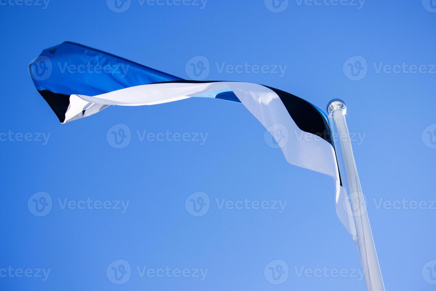 National Estonian flag waving against a clear blue sky, symbolizing national pride and identity with distinct horizontal blue, black, and white stripes. Copy space photo