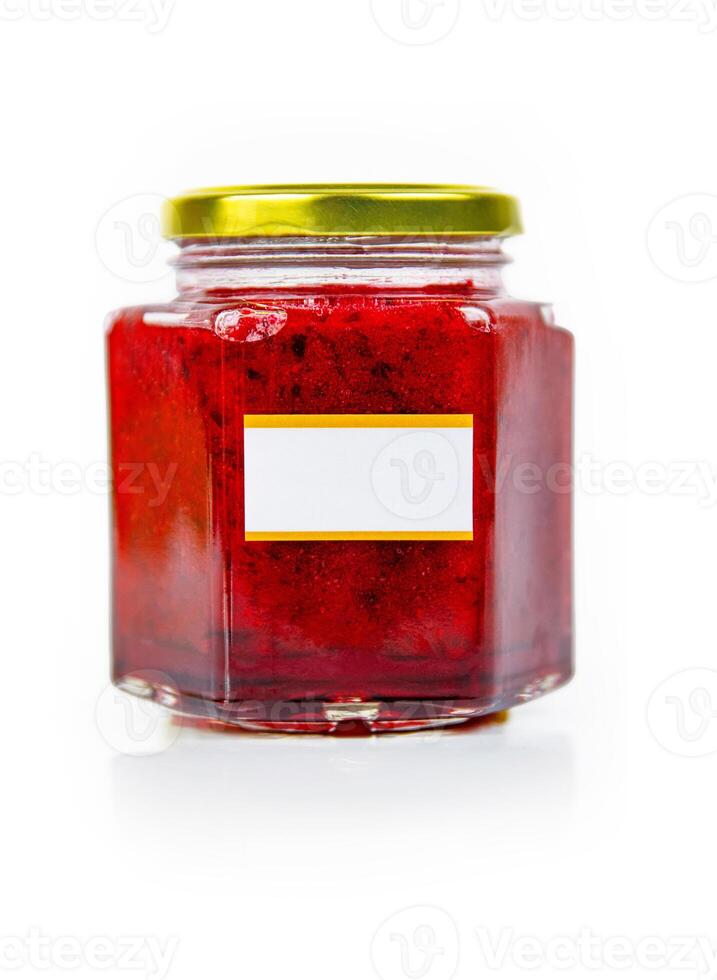 Hexagonal glass jar of homemade red currant berry or cranberry jam with a gold lid and blank label. Isaolated on white background. Copy space. photo