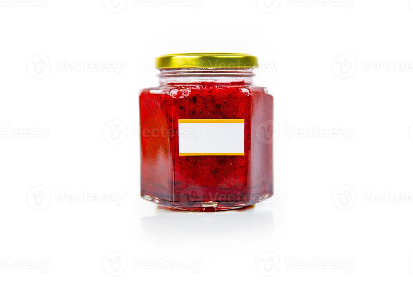 Hexagonal glass jar of homemade red currant berry or cranberry jam with a gold lid and blank label. Isaolated on white background. Copy space. photo