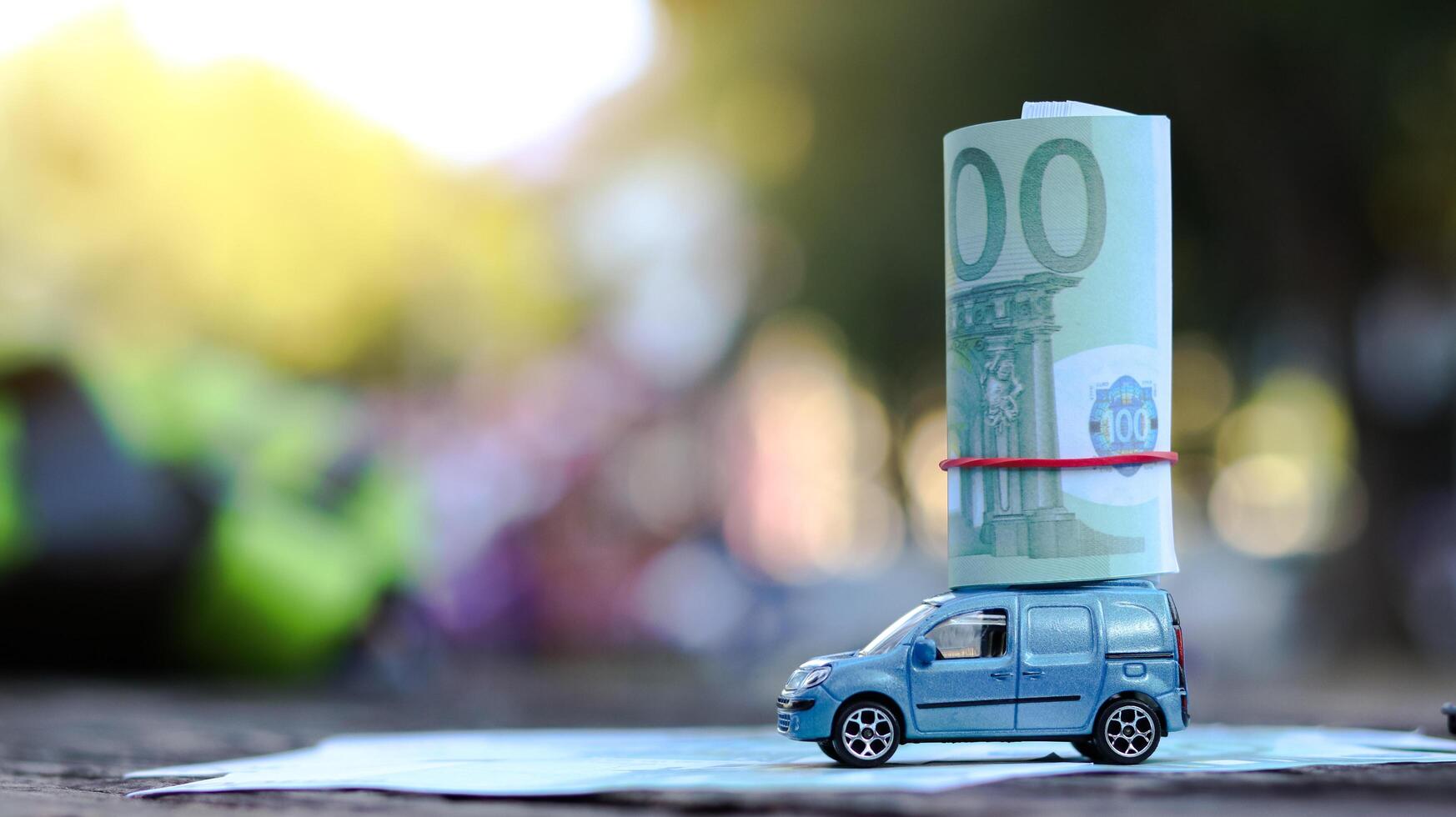 Model car with euro banknotes on blur background. Planning of saving for buying car, car loan and car insurance concept. photo