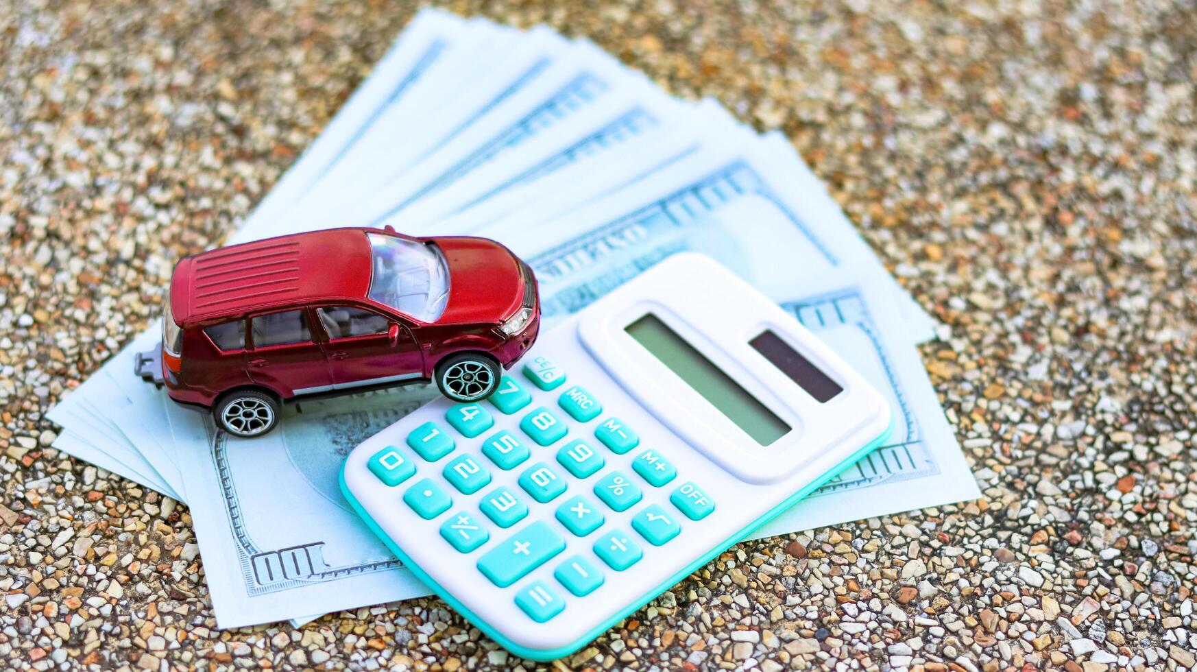 Model car and calculator are on euro banknotes with blur background. Planning of saving for buying car, car loan and car insurance concept. photo