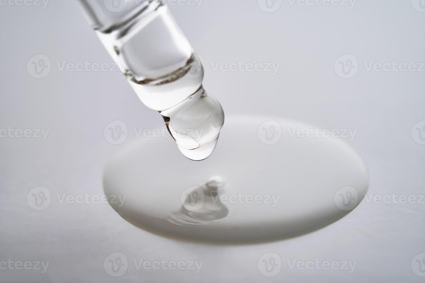 Dropper pipette with delicious serum with drop close-up. photo