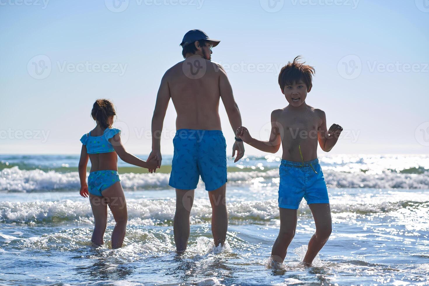 Family having fun in the sea waves during the holidays. photo