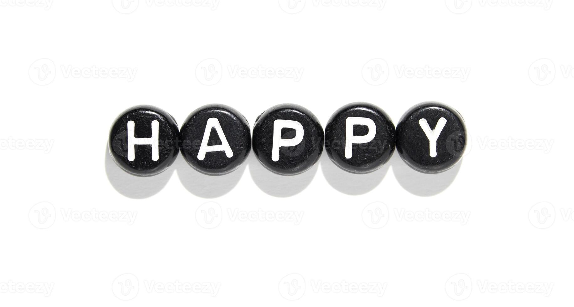 Black stones with white letters forming the word happy on white background with shadows photo