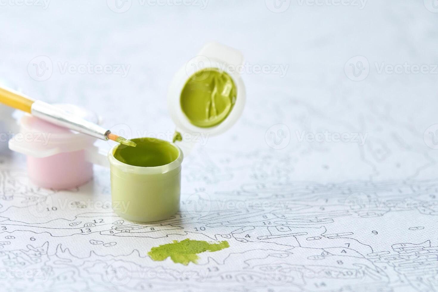 Diy paint by numbers kit with green paint and brush on canvas for relaxing creative activity and home decor enhancement. photo