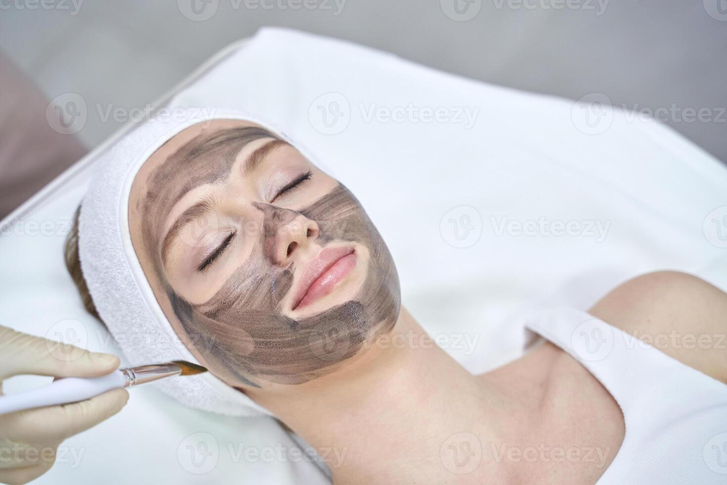 Rejuvenating facial treatment with clay mask at spa for relaxation and skincare. photo
