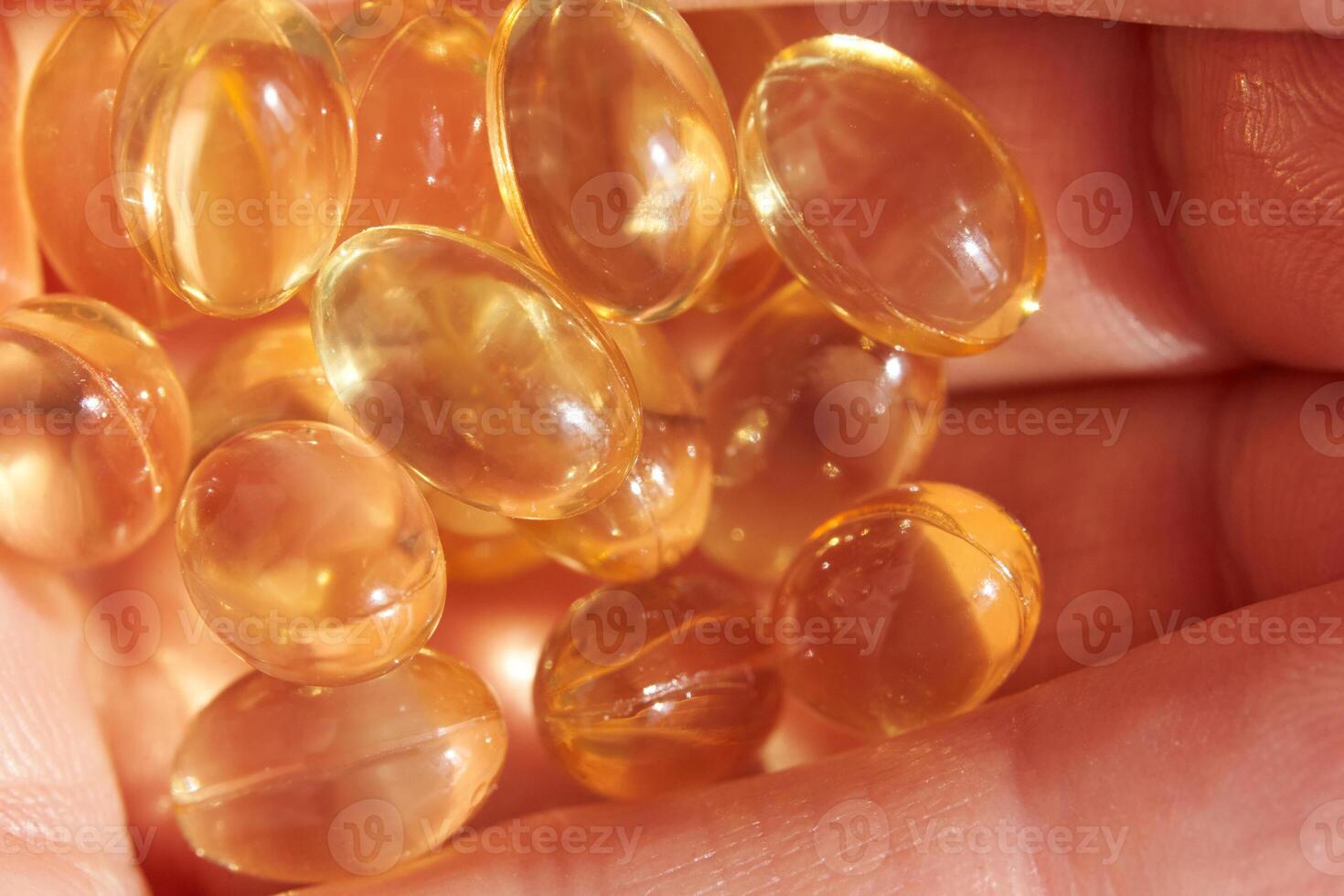 Close-up of golden omega-3 capsules in hand for health and wellness concepts. photo
