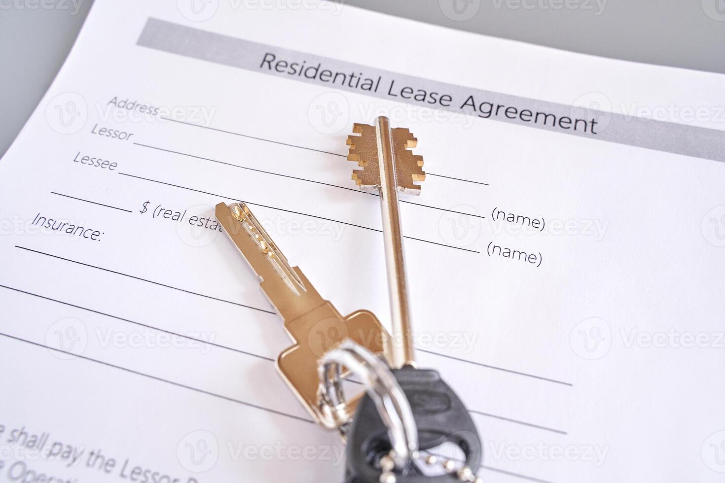 Keys on residential lease agreement document in real estate contract and housing concept photo