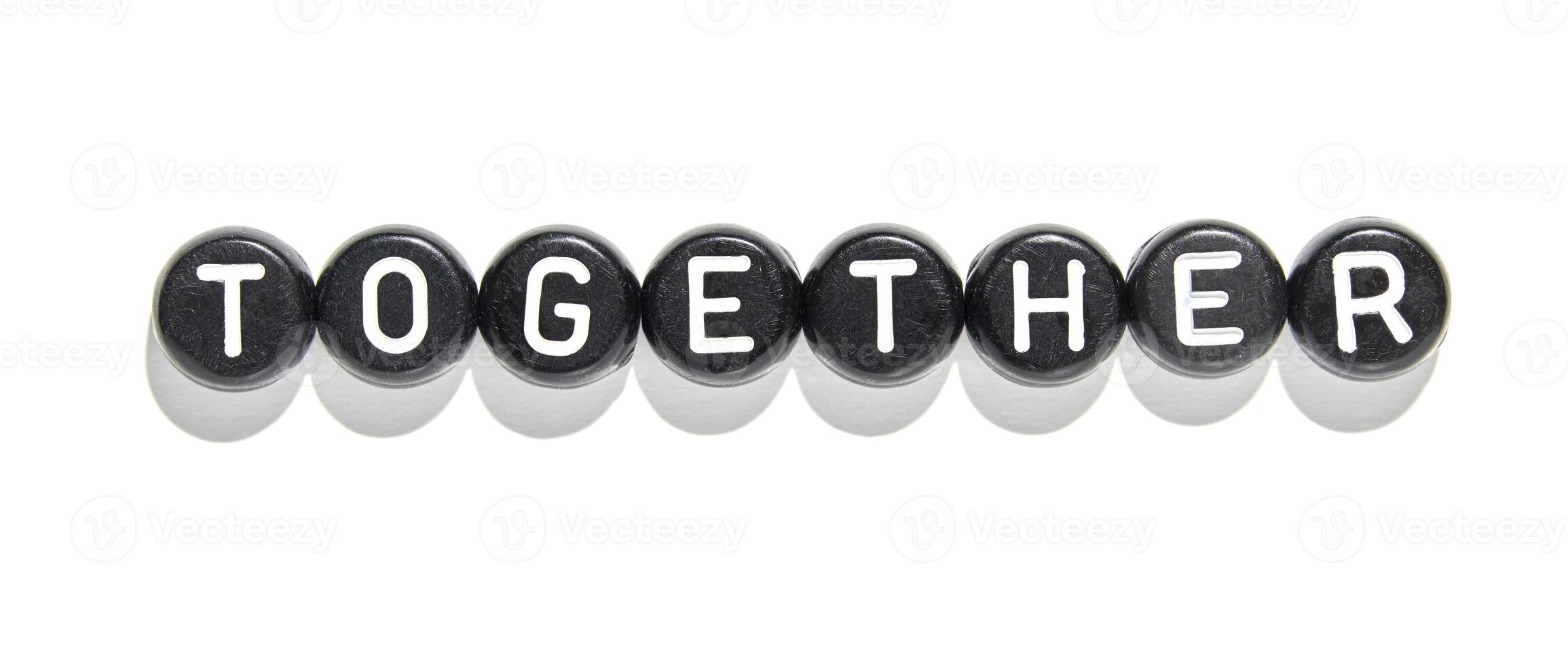 Together word formed with black and white letter beads symbolizing unity and collaboration on white background photo