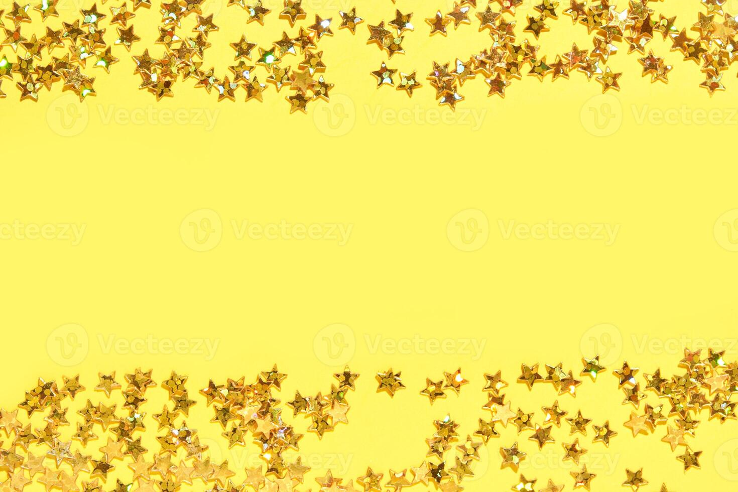 Shimmering gold star confetti on vibrant yellow background for festive celebrations and creative designs. photo
