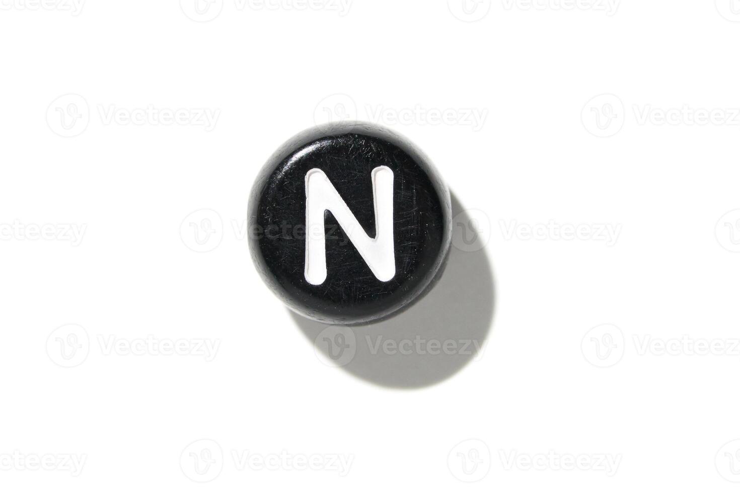 Round black button with white letter n on a white background. photo