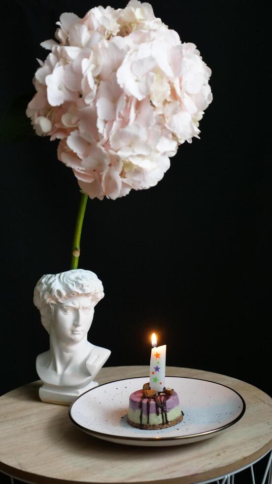 A birthday cake with a candle on top of a table photo