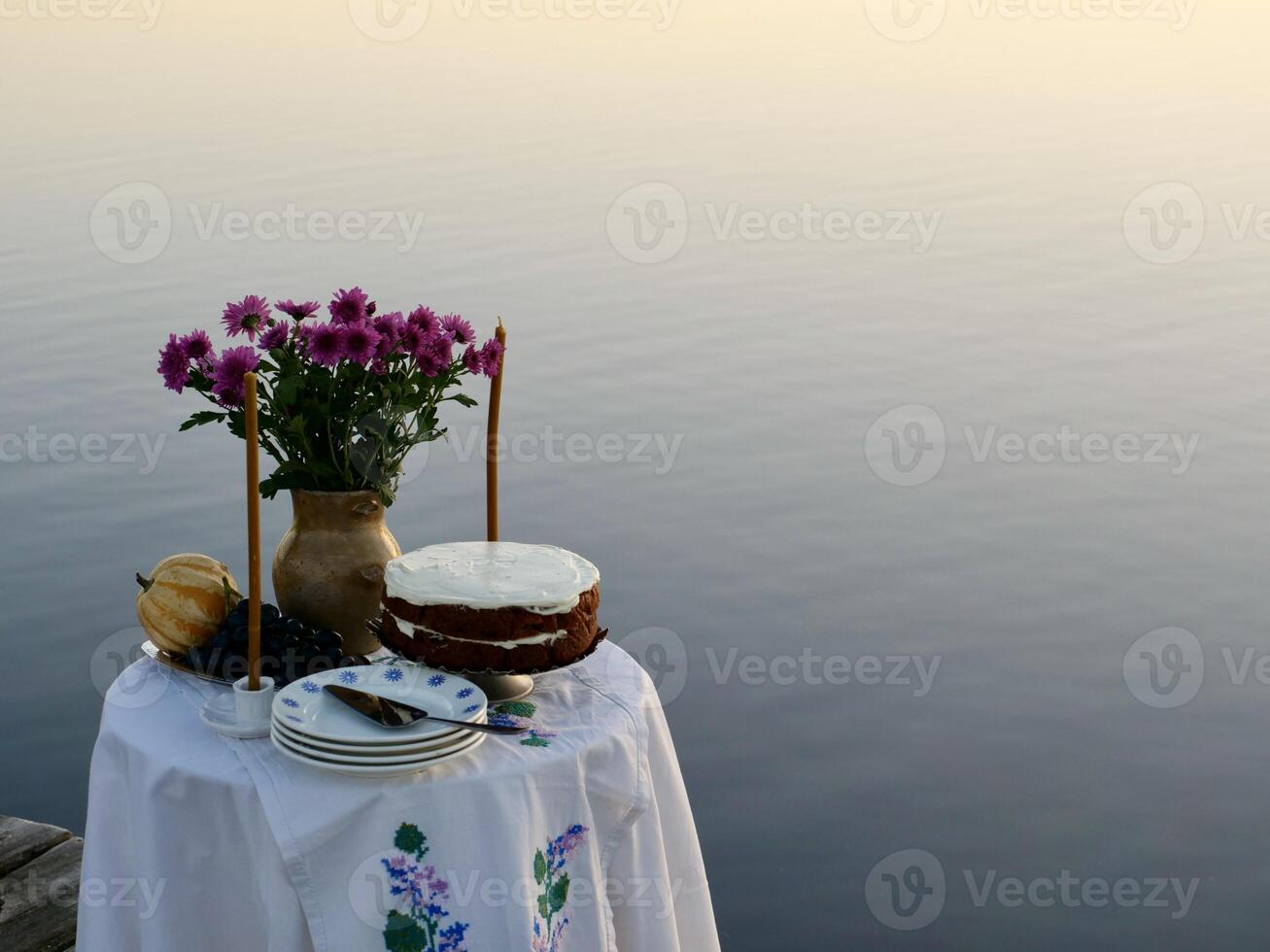 A table with a cake and flowers on it photo