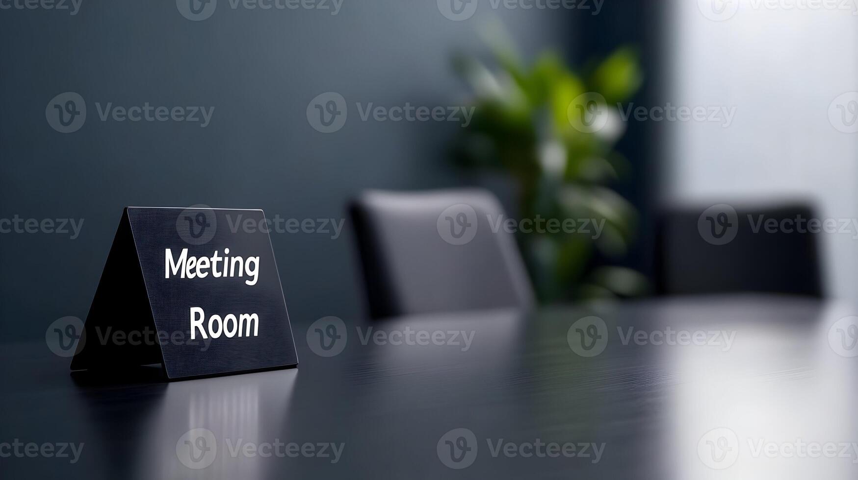 Meeting Room sign on office glass wall with empty collaboration workspace, large table, and armchairs in background. photo