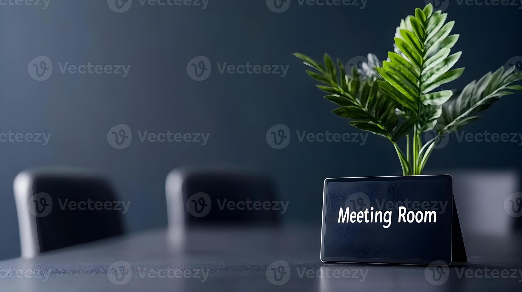 Meeting Room sign on office glass wall with empty collaboration workspace, large table, and armchairs in background. photo