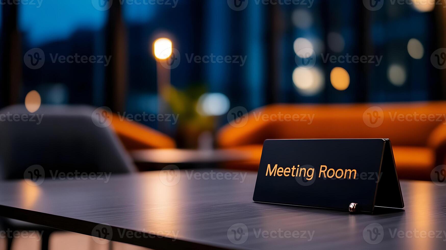Meeting Room sign on office glass wall with empty collaboration workspace, large table, and armchairs in background. photo
