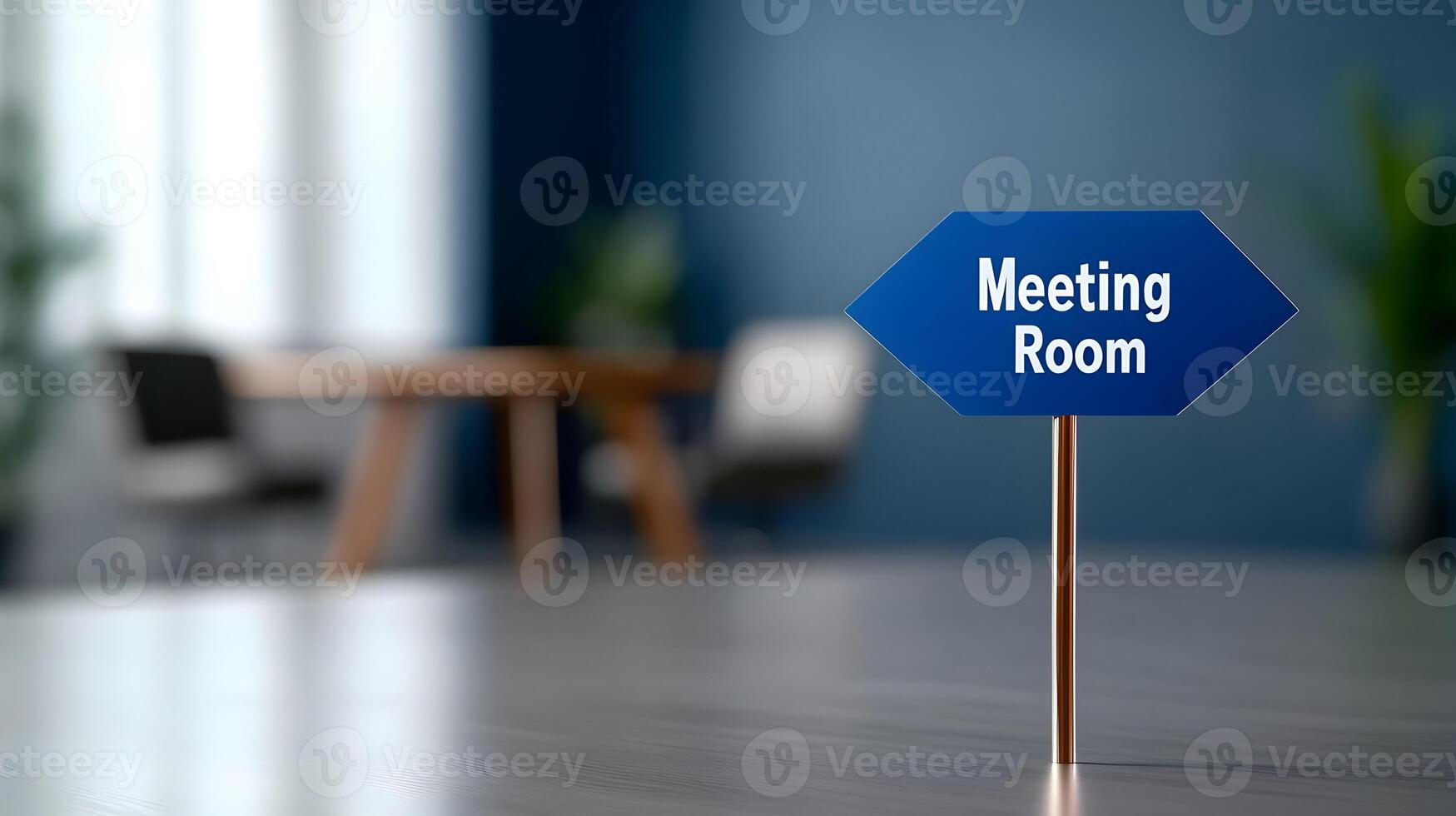 Meeting Room sign on office glass wall with empty collaboration workspace, large table, and armchairs in background. photo