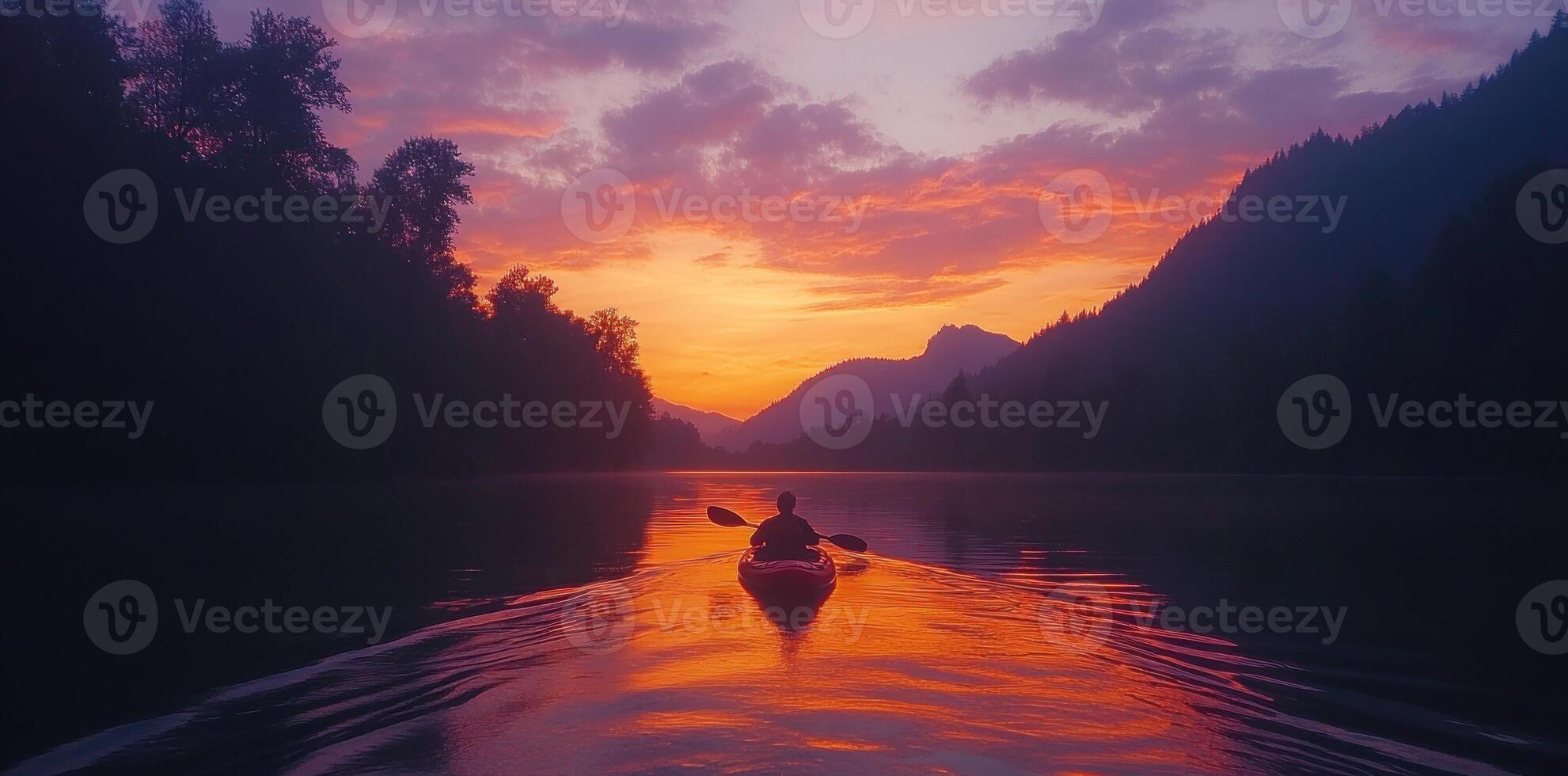 Solitary Kayaker Paddling Through Mountain Lake at Sunset photo