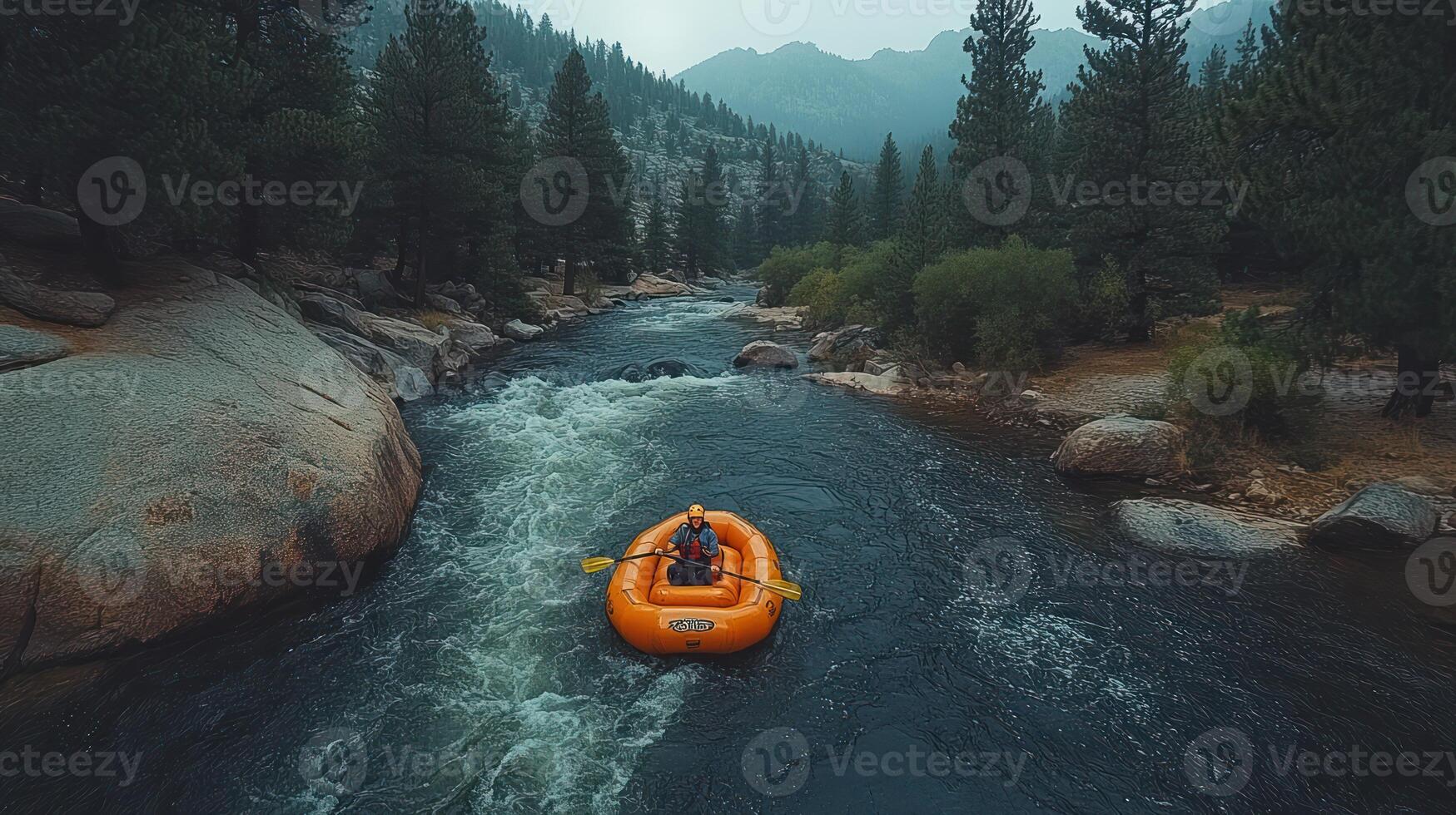 A lone rafter navigates a rushing river amidst towering trees and a misty mountain backdrop. photo