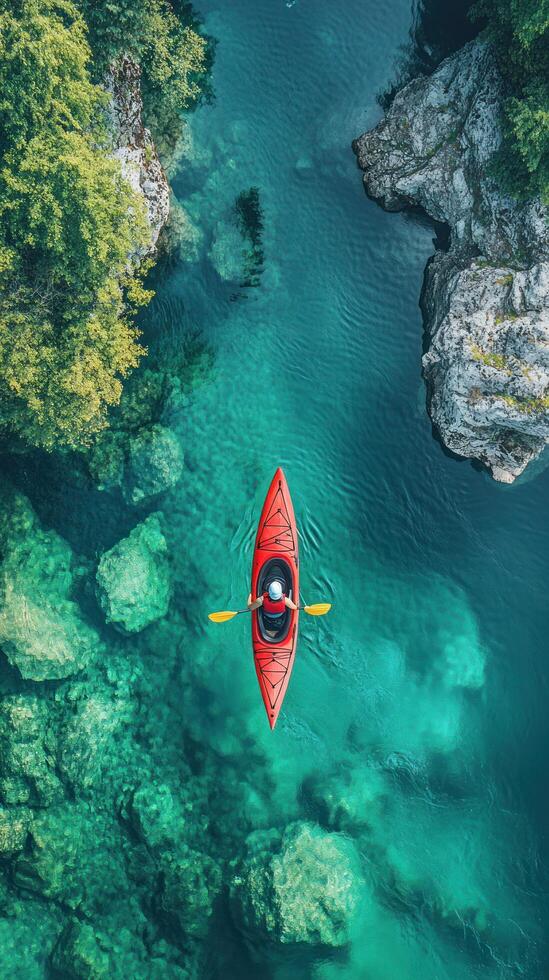 An Aerial View of a Red Kayak on a Clear Teal River photo