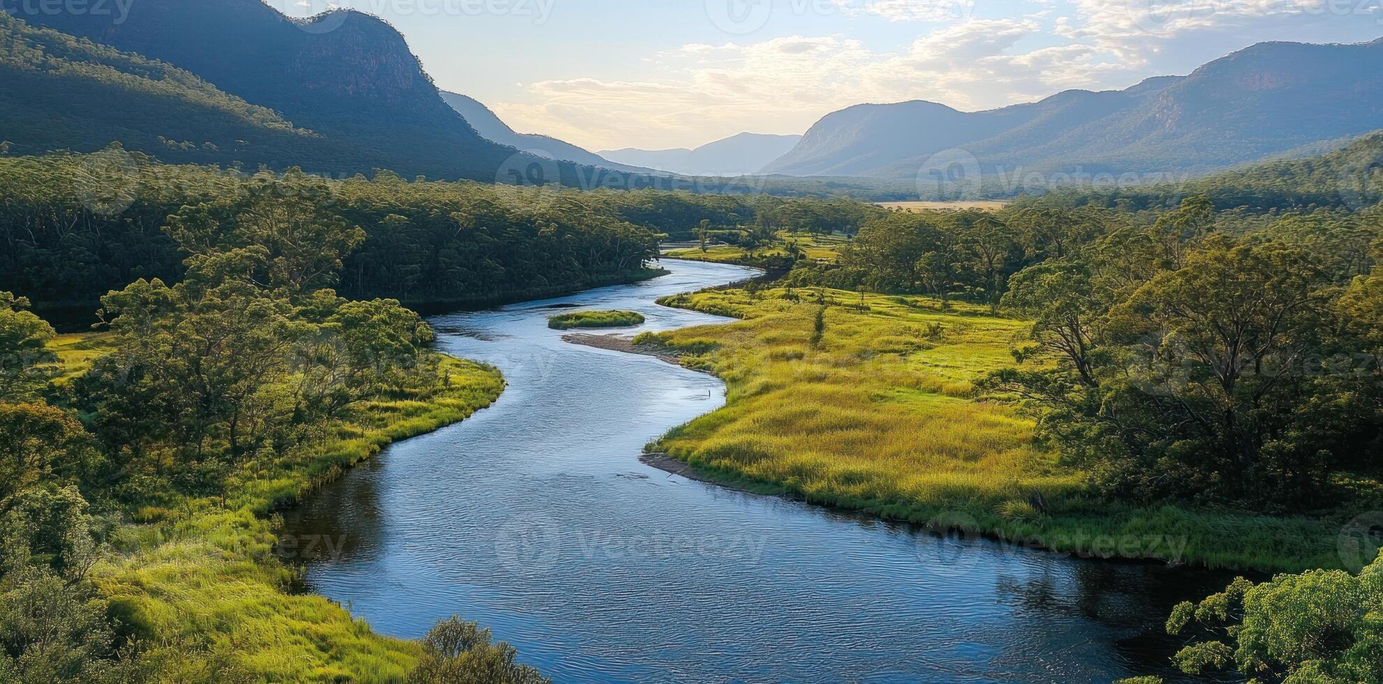 A Serpentine River Winding Through a Lush Green Valley Surrounded by Mountains photo
