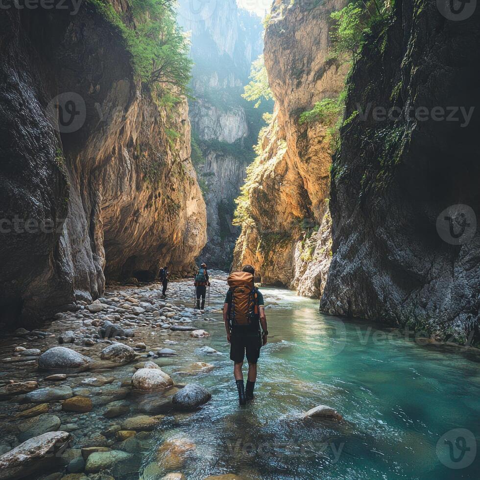 Hikers Traverse a Narrow, Rocky Gorge with a Flowing Stream photo