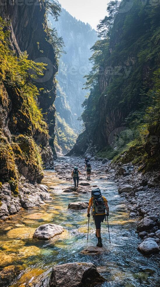 Hikers Traverse a Rocky Stream in a Narrow Mountain Gorge photo