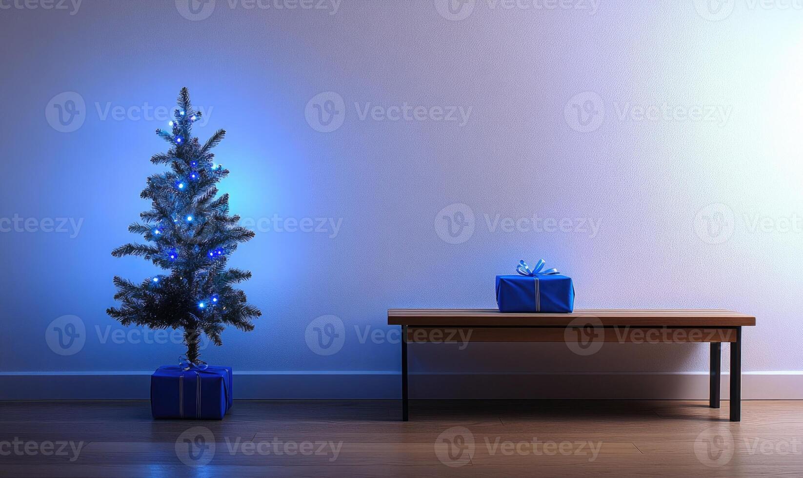 A blue Christmas tree sits in front of a white wall photo
