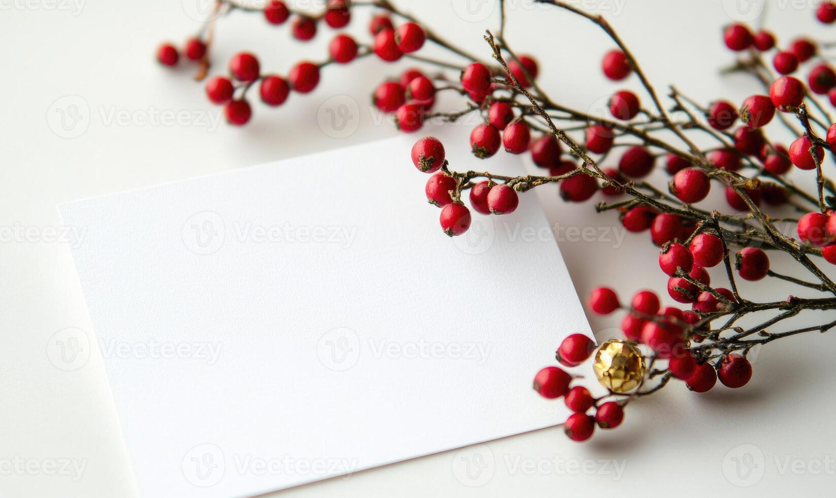 A white card with a blank space sits on a table with red berries photo