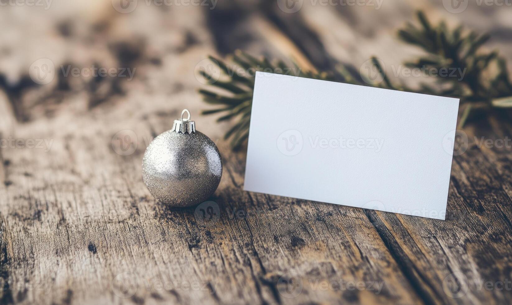 A white card with a name on it is sitting next to a silver ornament photo