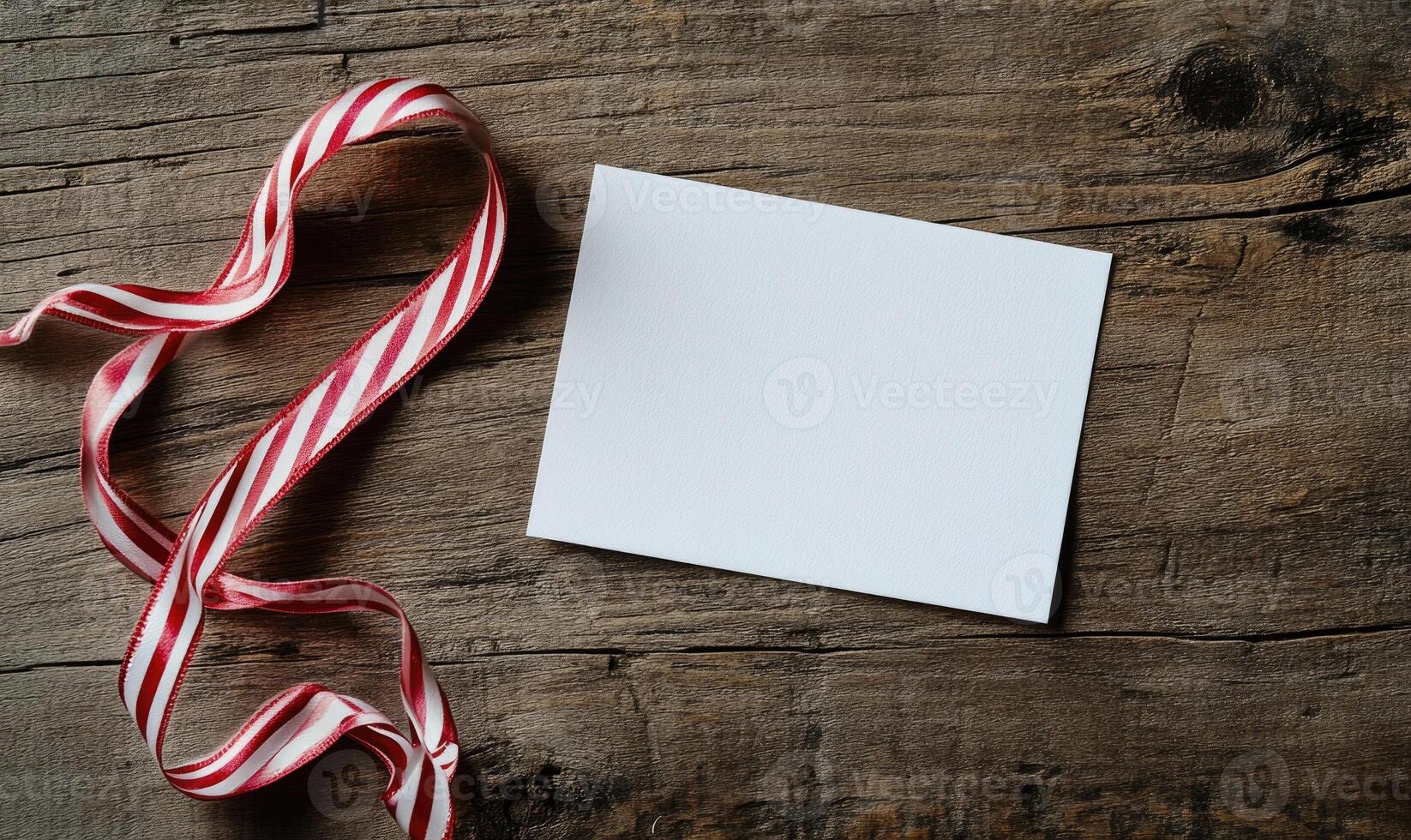 A white card with a red ribbon on top of it photo