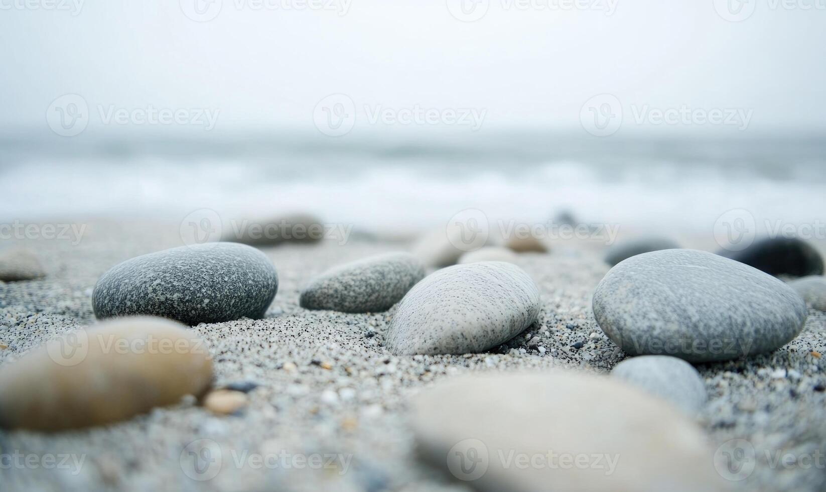 A beach scene with a large number of rocks scattered across the sand photo