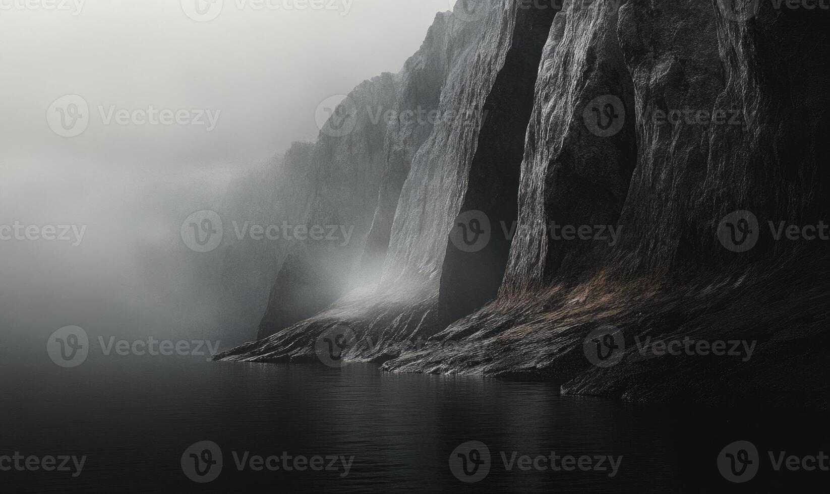 A mountain range with a foggy sky and a body of water in the foreground photo