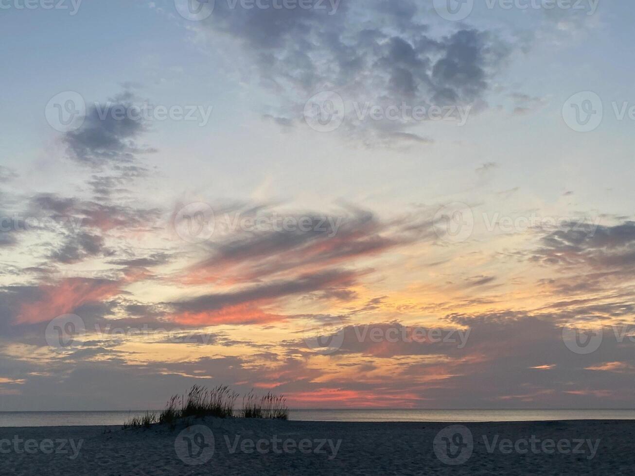 Quiet evening Baltic landscape on the sea, calm sunset on the beach, the golden sun is covered by gray clouds, the atmosphere of tranquility, rest and serenity photo
