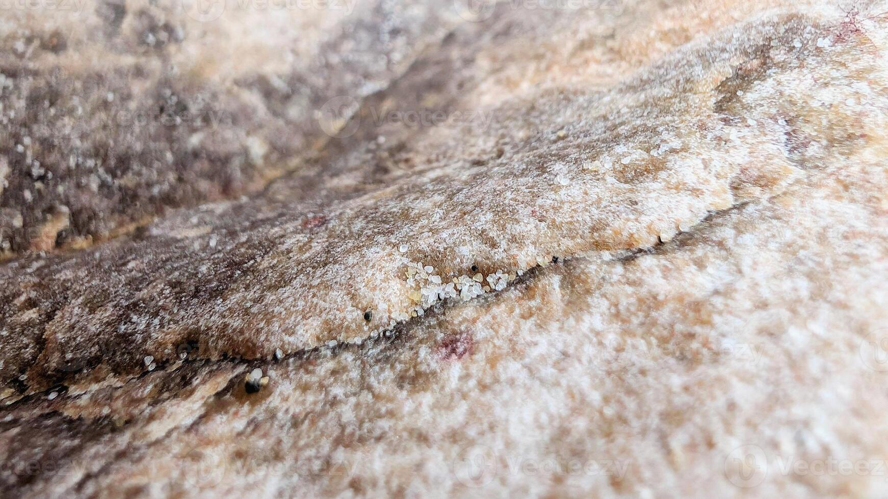 Nature textured backdrop. Abstract volumetric shape, stone texture with crack lines and focus close up. Marble-colored with macro photos of grains of sand. Warm shades of hard, cold rock