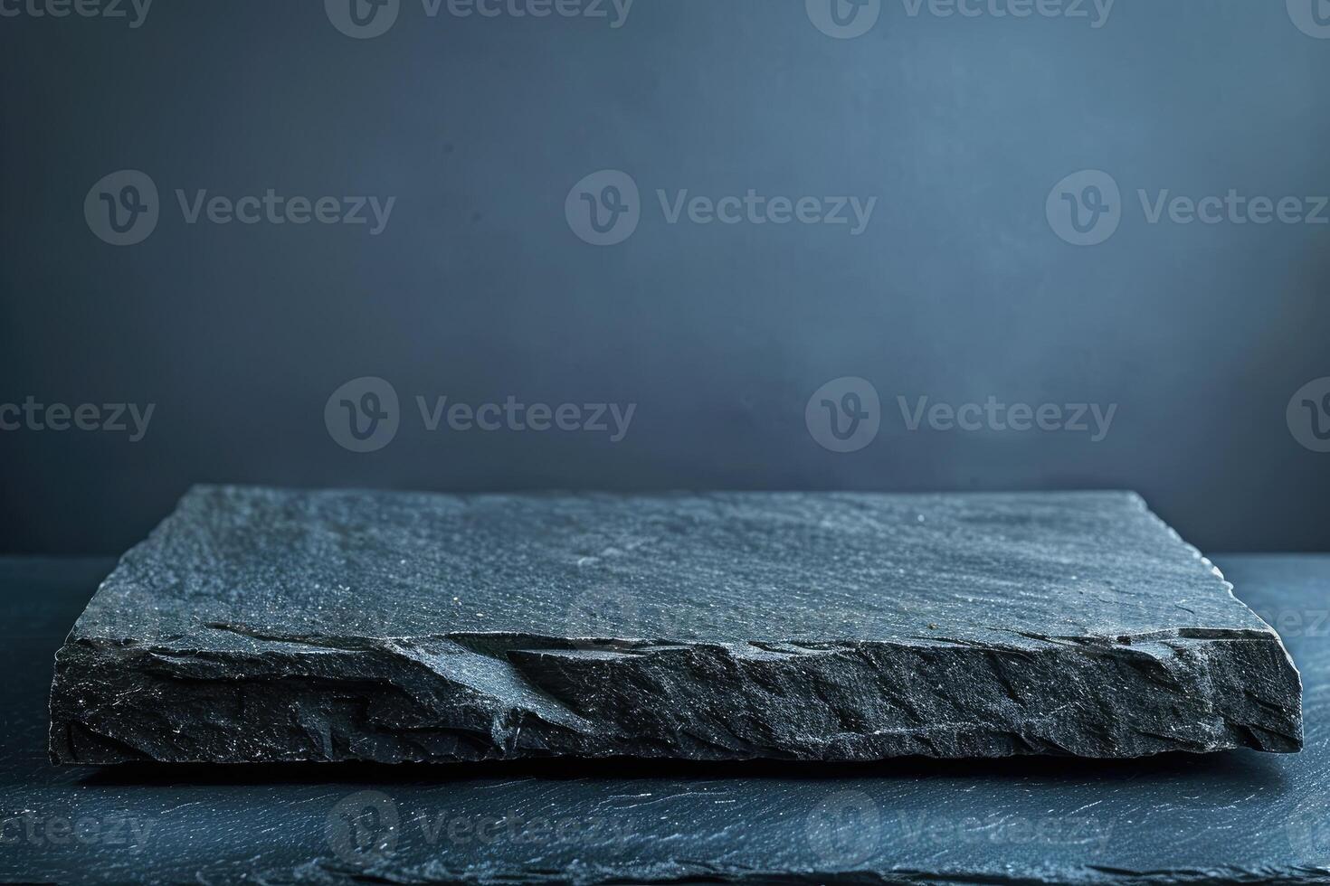 Empty black stone table top, desk or shelf isolated on dark pale blue background photo