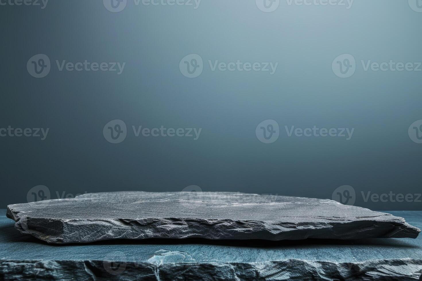 Empty black stone table top, desk or shelf isolated on dark pale blue background photo