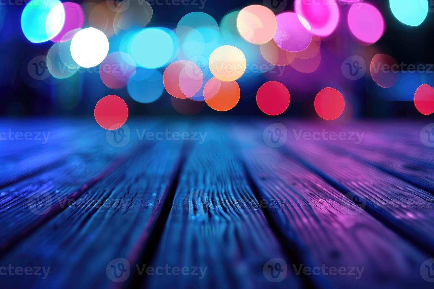 Defocused city lights create a colorful bokeh effect on a wooden boardwalk at night. photo