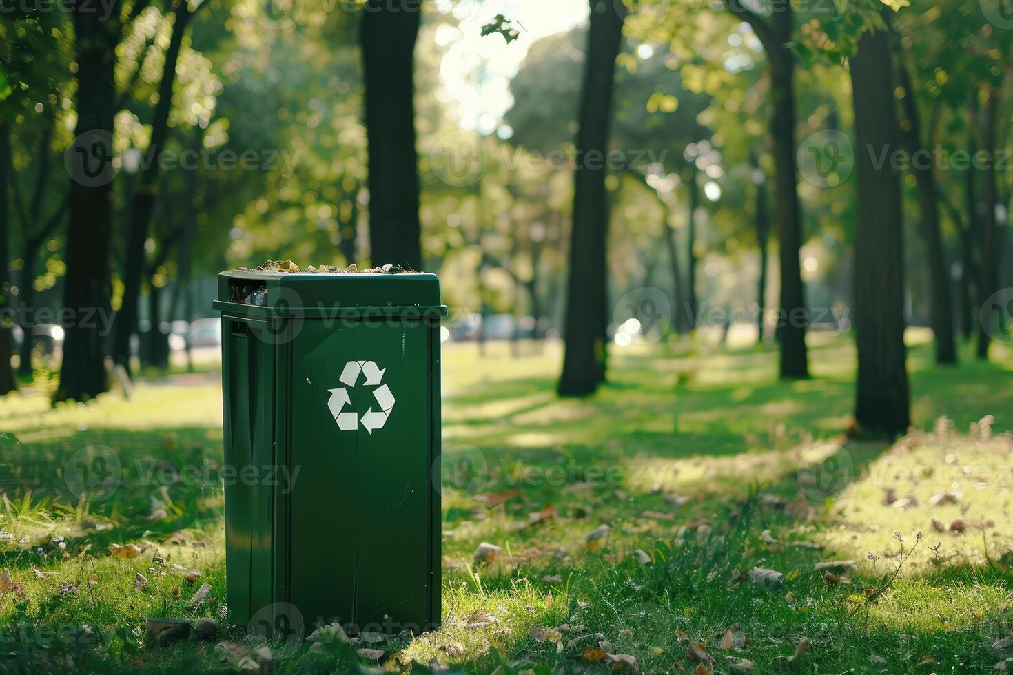 Individual contributing to environmental sustainability by using a green recycle bin in a park. photo