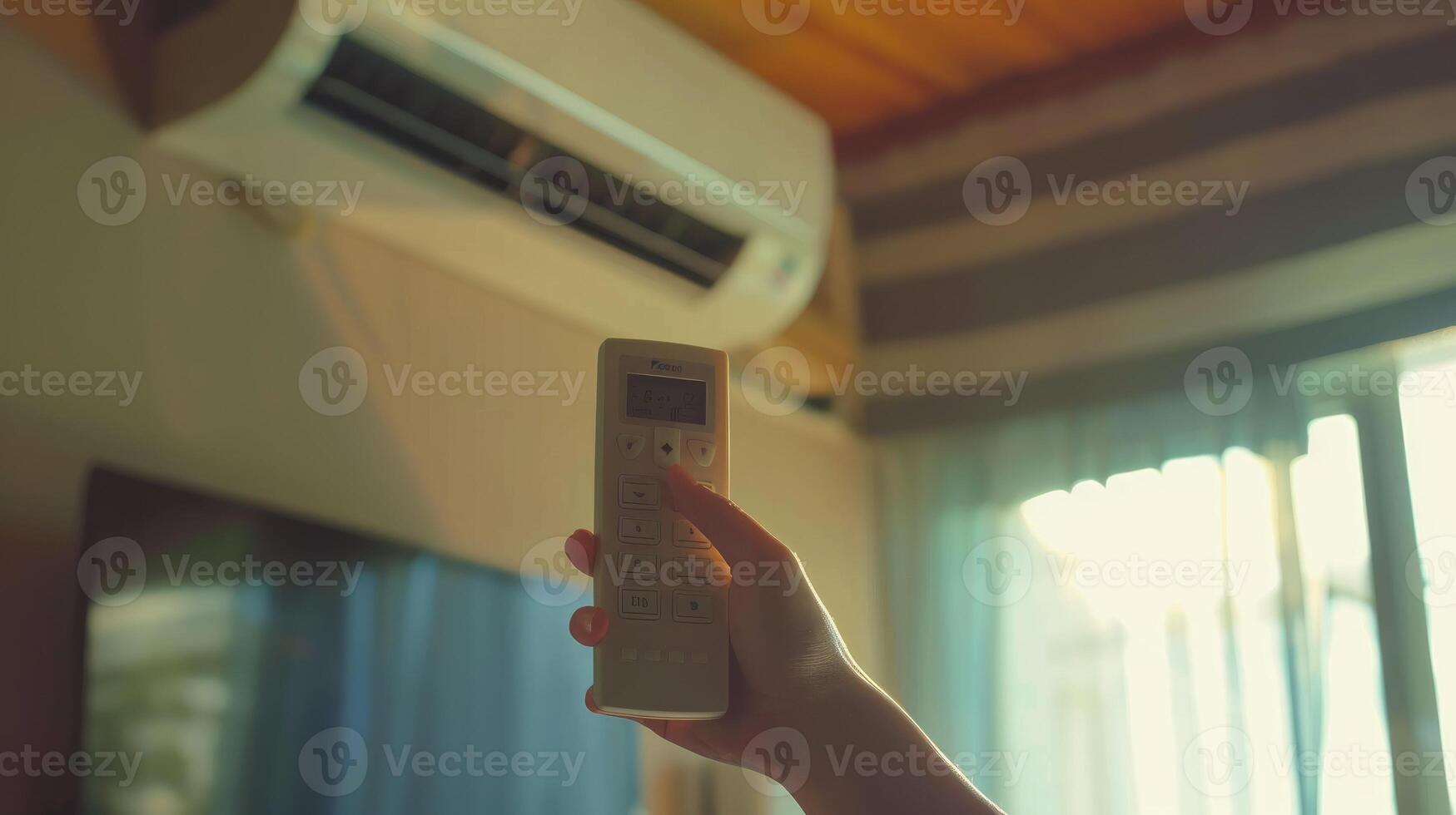 hand holding an air conditioner remote. Air conditioner inside the room with woman operating remote controller photo
